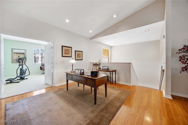 home office featuring light hardwood / wood-style flooring and vaulted ceiling