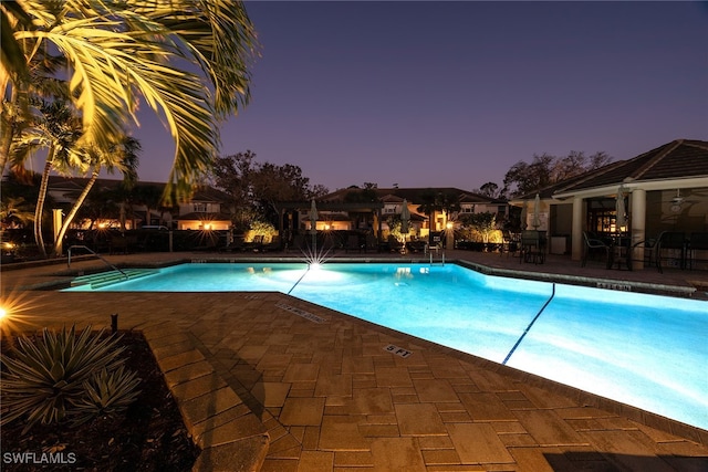 pool at dusk with a patio