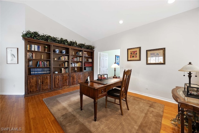 office area with wood-type flooring and vaulted ceiling