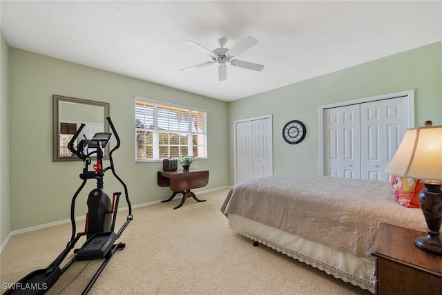 bedroom with carpet flooring, ceiling fan, and two closets