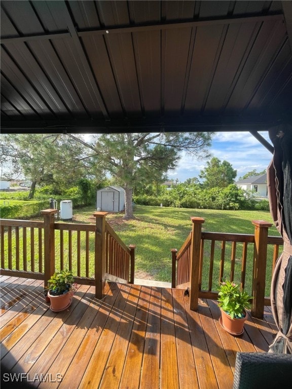 deck featuring a yard and a storage unit