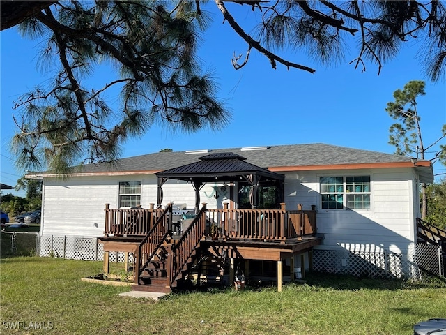 rear view of property featuring a gazebo, a yard, and a wooden deck