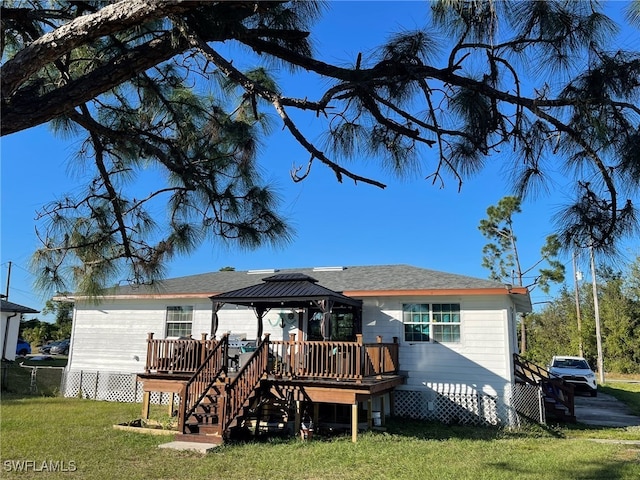 rear view of house featuring a gazebo, a yard, and a wooden deck