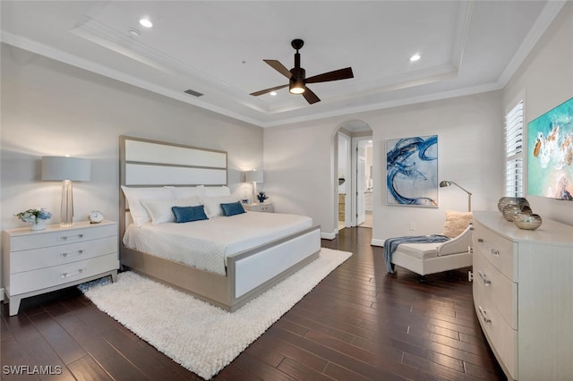 bedroom with ceiling fan, dark hardwood / wood-style flooring, crown molding, and a raised ceiling