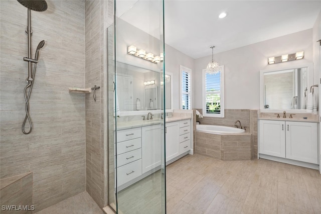 bathroom with vanity, a notable chandelier, and plus walk in shower