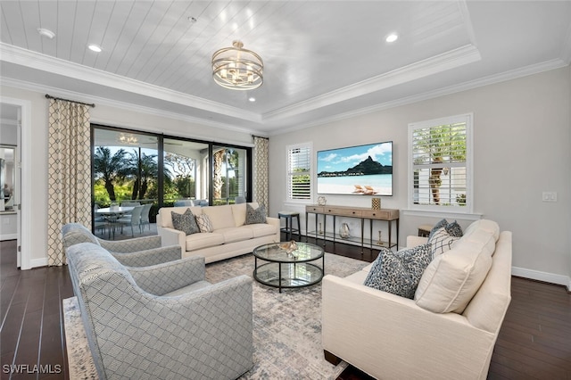 living room featuring an inviting chandelier, dark hardwood / wood-style flooring, ornamental molding, and a raised ceiling