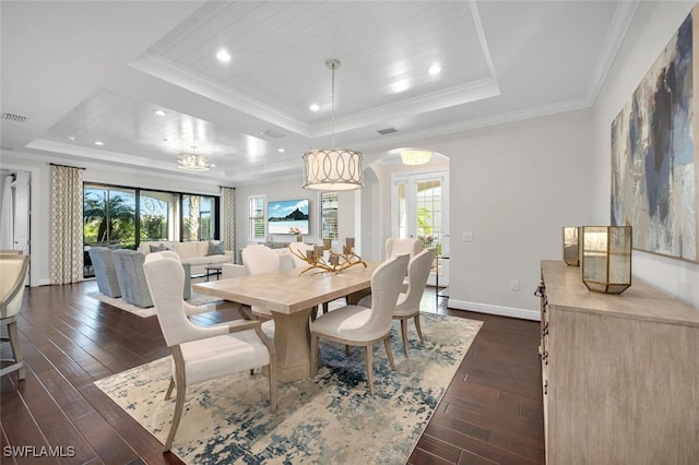 dining space featuring a tray ceiling, dark hardwood / wood-style flooring, and crown molding