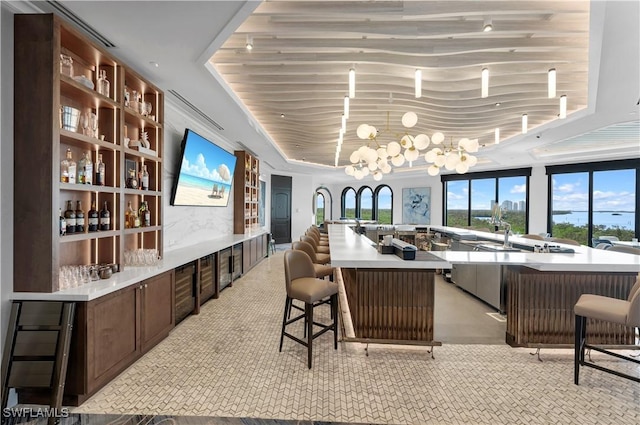 bar with a raised ceiling and a notable chandelier