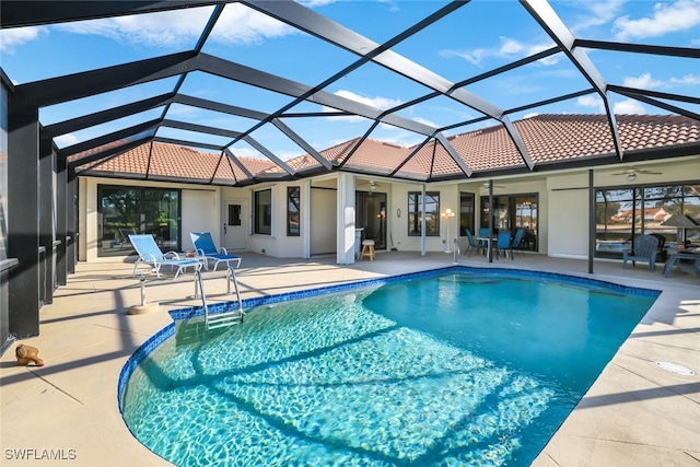 view of swimming pool featuring ceiling fan, a patio area, and a lanai