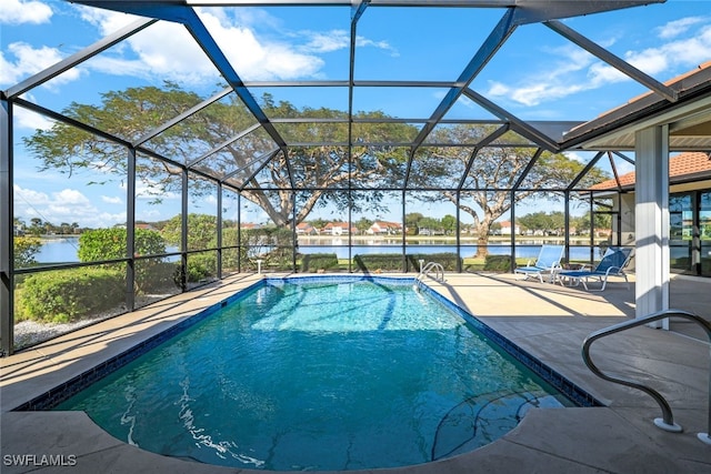 view of swimming pool featuring glass enclosure, a patio area, and a water view