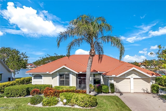 mediterranean / spanish house with a front lawn and a garage