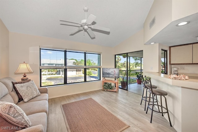 living room with high vaulted ceiling, light hardwood / wood-style flooring, and ceiling fan