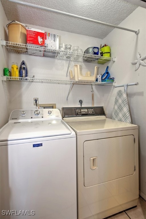 laundry area featuring light tile patterned flooring, independent washer and dryer, and a textured ceiling