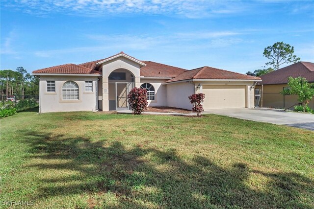 mediterranean / spanish house with a front yard and a garage