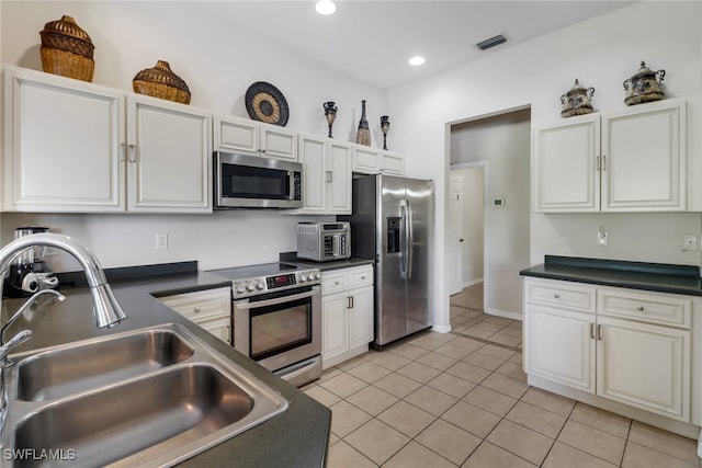 kitchen featuring white cabinets, light tile patterned floors, stainless steel appliances, and sink