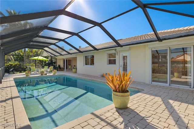 view of swimming pool with a patio and glass enclosure