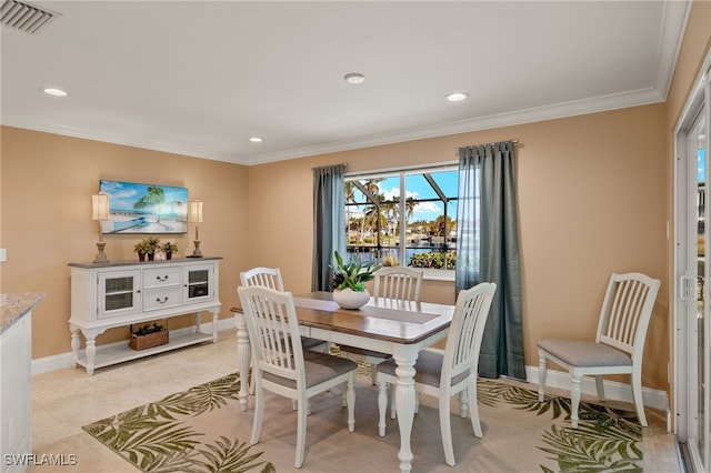 dining room with crown molding and light tile patterned floors