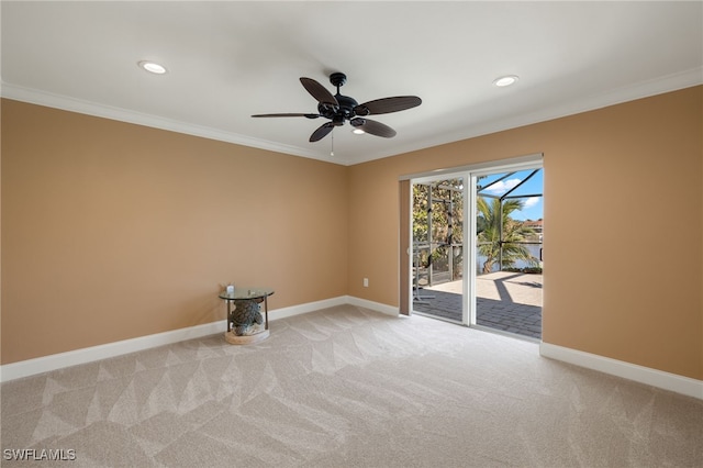 spare room featuring light colored carpet, ceiling fan, and ornamental molding