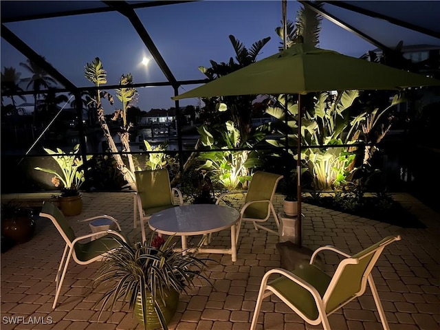 patio at night featuring glass enclosure