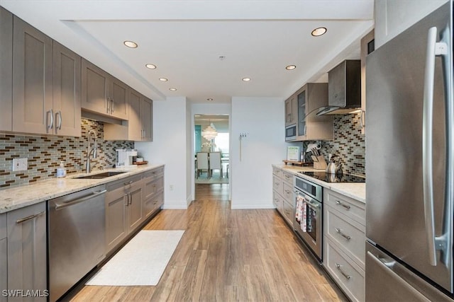7515 Pelican Bay Blvd Unit 14A, Naples, FL 34108 - kitchen with stainless steel appliances, a sink, recessed lighting, wall chimney exhaust hood, and backsplash