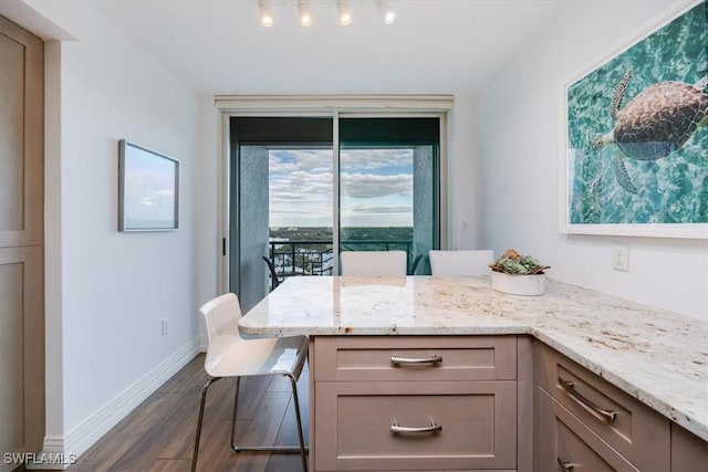 7515 Pelican Bay Blvd Unit 14A, Naples, FL 34108 - kitchen featuring light stone countertops, dark wood finished floors, and baseboards