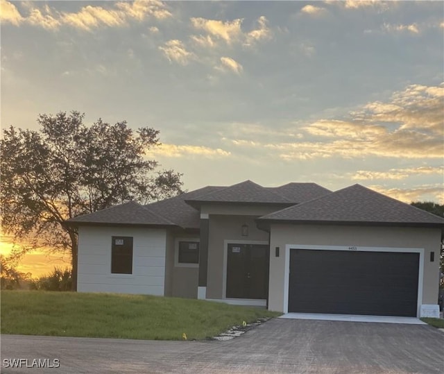 prairie-style home with a lawn and a garage