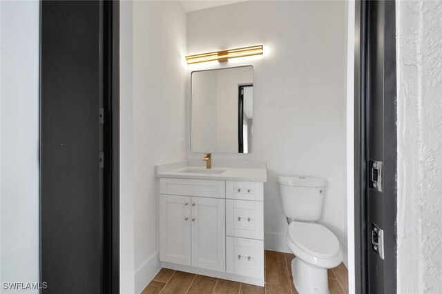 bathroom featuring hardwood / wood-style floors, vanity, and toilet