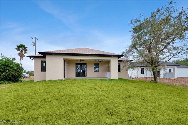 back of house featuring ceiling fan and a yard