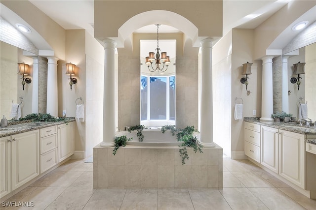 bathroom with tile patterned floors, vanity, a relaxing tiled tub, and a notable chandelier