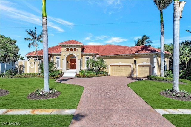 mediterranean / spanish home with a front lawn and a garage