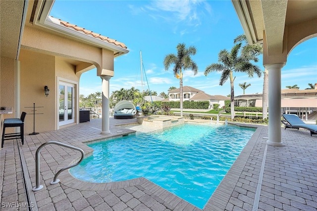 view of pool featuring an in ground hot tub, french doors, and a patio