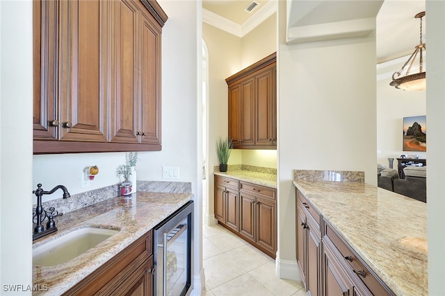 kitchen with light stone counters, beverage cooler, crown molding, sink, and pendant lighting