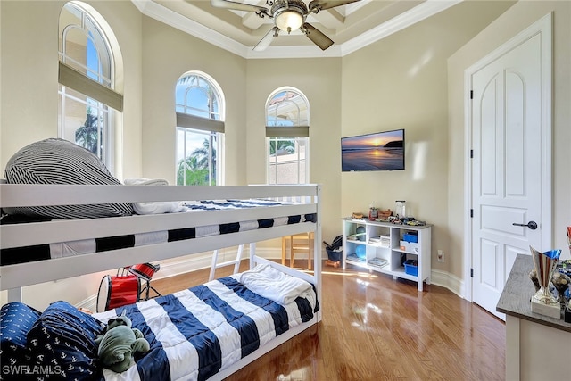 bedroom featuring hardwood / wood-style flooring, ceiling fan, and crown molding