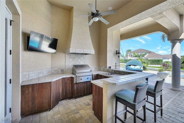 view of patio / terrace featuring area for grilling, an outdoor bar, and ceiling fan