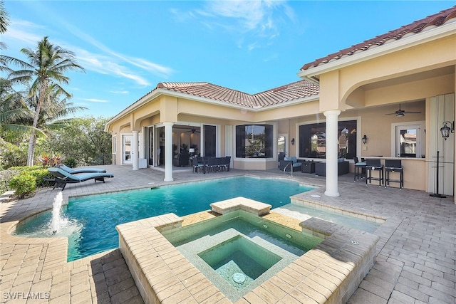 view of swimming pool with ceiling fan, a patio area, an outdoor living space, and an in ground hot tub