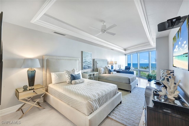 bedroom with a raised ceiling, ceiling fan, and ornamental molding