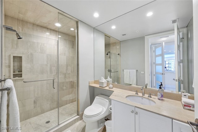 bathroom with vanity, toilet, and an enclosed shower