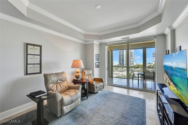 living area featuring a tray ceiling and crown molding