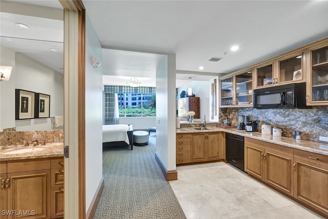 kitchen with black appliances, light stone countertops, sink, and tasteful backsplash