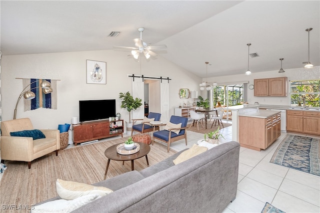 living room featuring lofted ceiling, sink, ceiling fan, a barn door, and light tile patterned floors