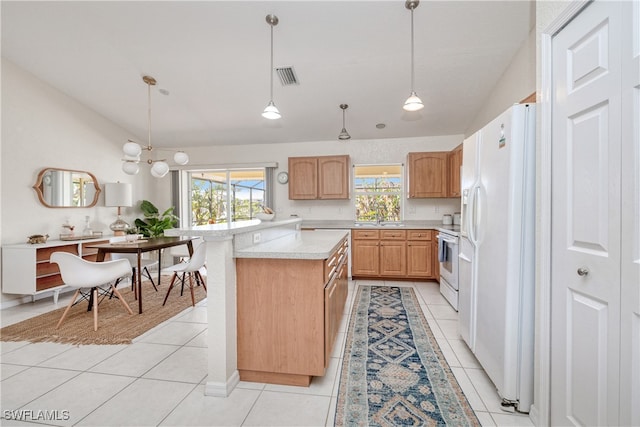 kitchen featuring sink, light brown cabinets, hanging light fixtures, white appliances, and light tile patterned floors