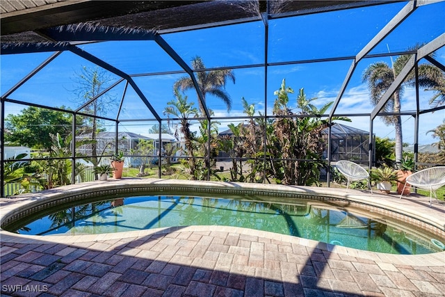 view of swimming pool with glass enclosure and a patio area