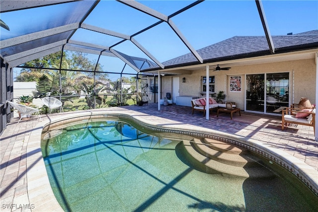 view of swimming pool with glass enclosure, ceiling fan, a patio, and an outdoor living space