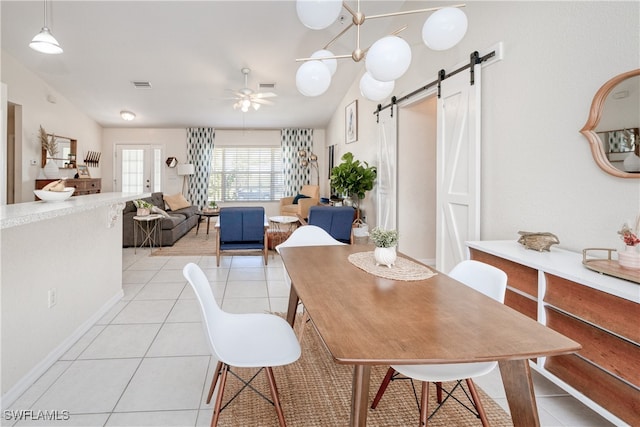 dining room featuring light tile patterned floors, a barn door, and ceiling fan