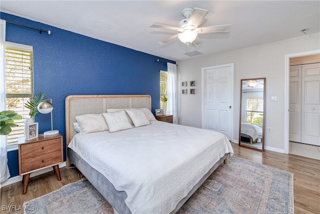 bedroom with ceiling fan, a closet, and dark wood-type flooring