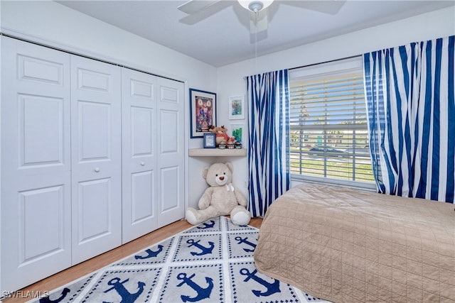 bedroom with ceiling fan, wood-type flooring, and a closet