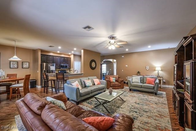 living room with dark hardwood / wood-style floors and ceiling fan