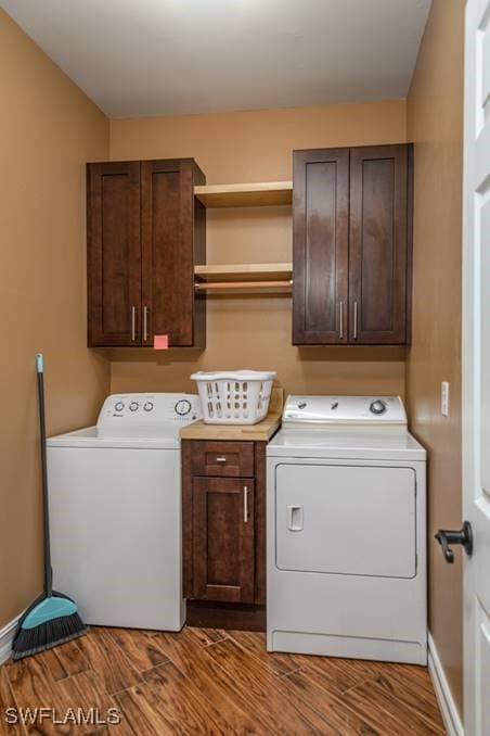 clothes washing area featuring washer and dryer, cabinets, and hardwood / wood-style floors