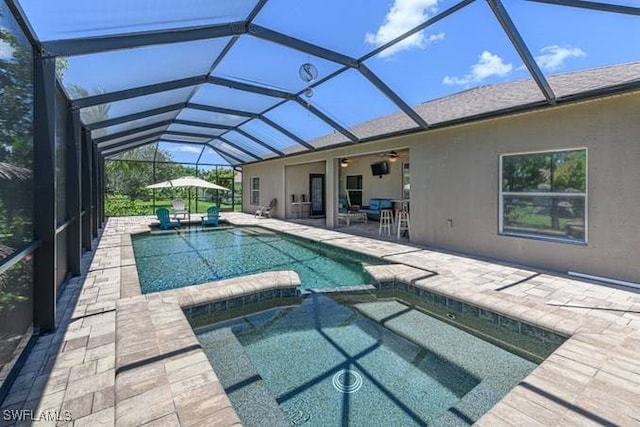 view of swimming pool featuring an in ground hot tub, a patio, and glass enclosure