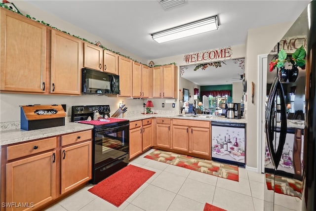 kitchen featuring sink, light tile patterned floors, and black appliances